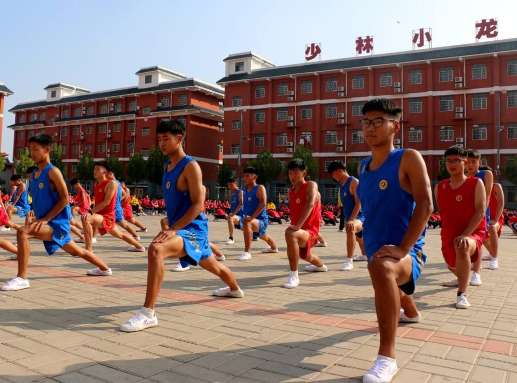 image shows students doing leg stretches