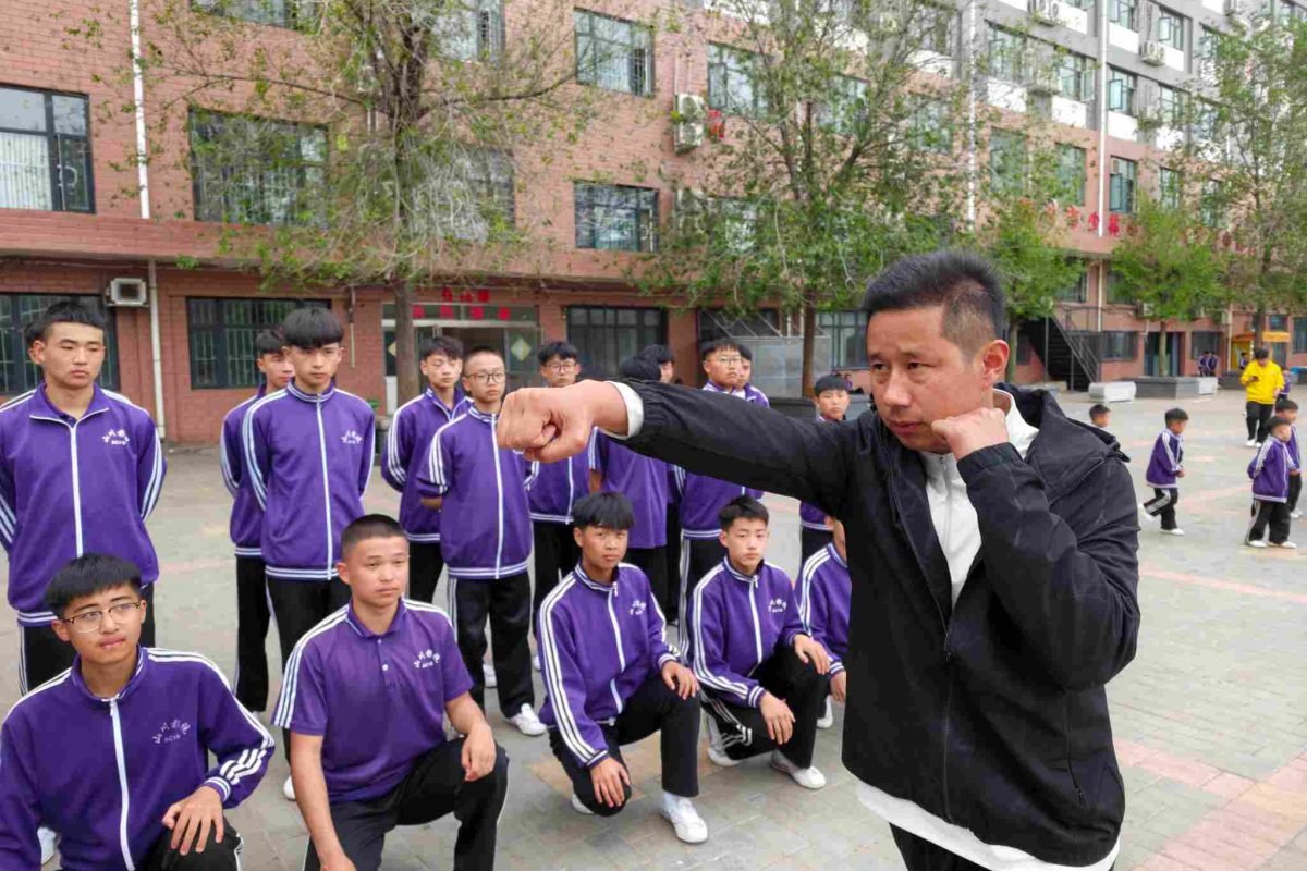image shows a master teaching students shaolin kung fu and tai chi